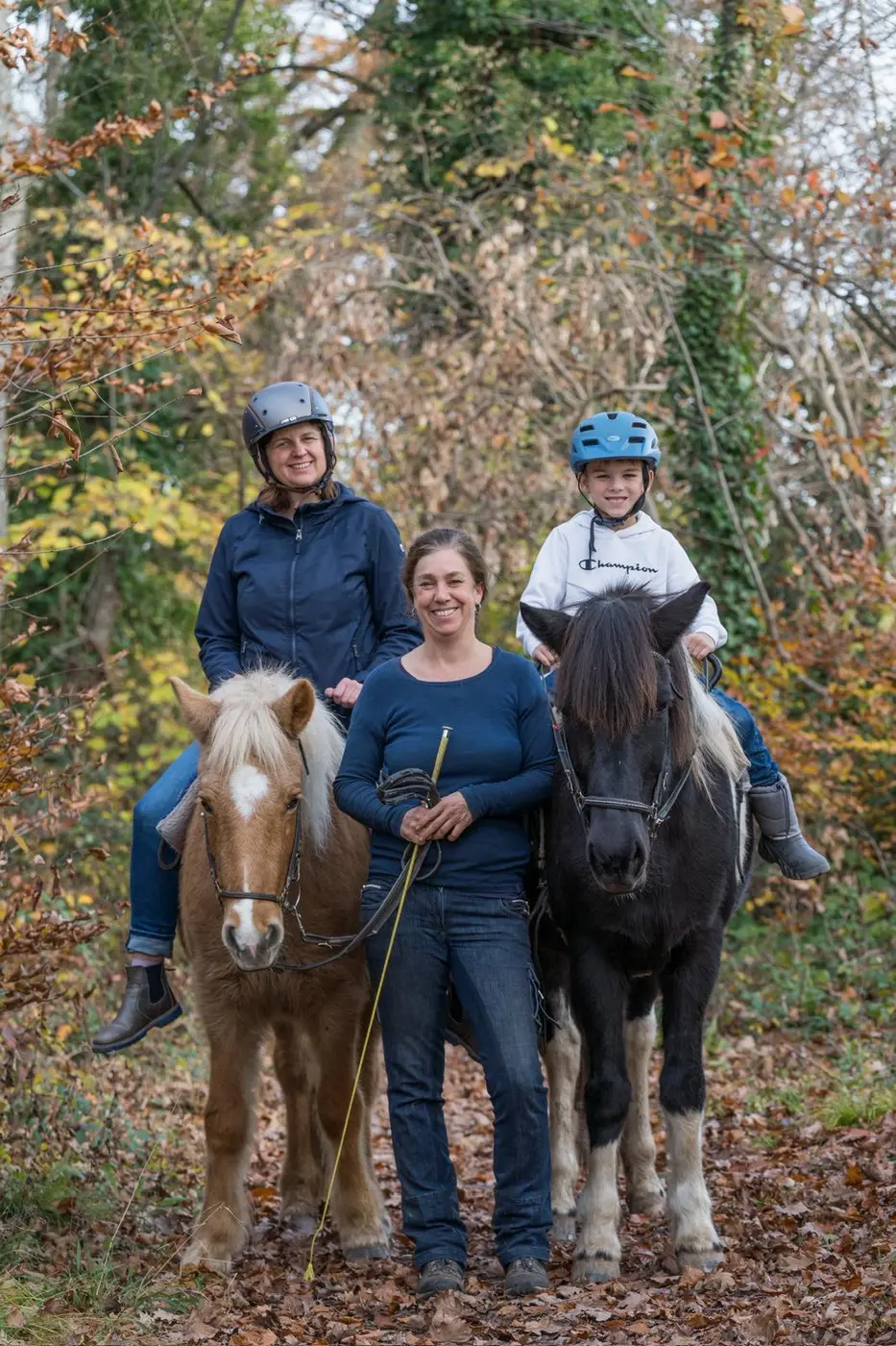 Drei Generationen gemeinsam mit zwei Islandpferden im Herbstwald